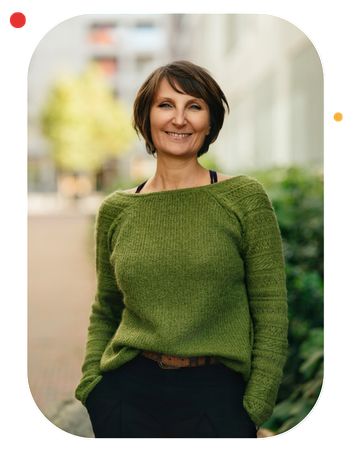 Nathalie Ranno rédactrice indépendante à Rennes, debout mains dans les poches, sourire, pull vert, pantalon noir