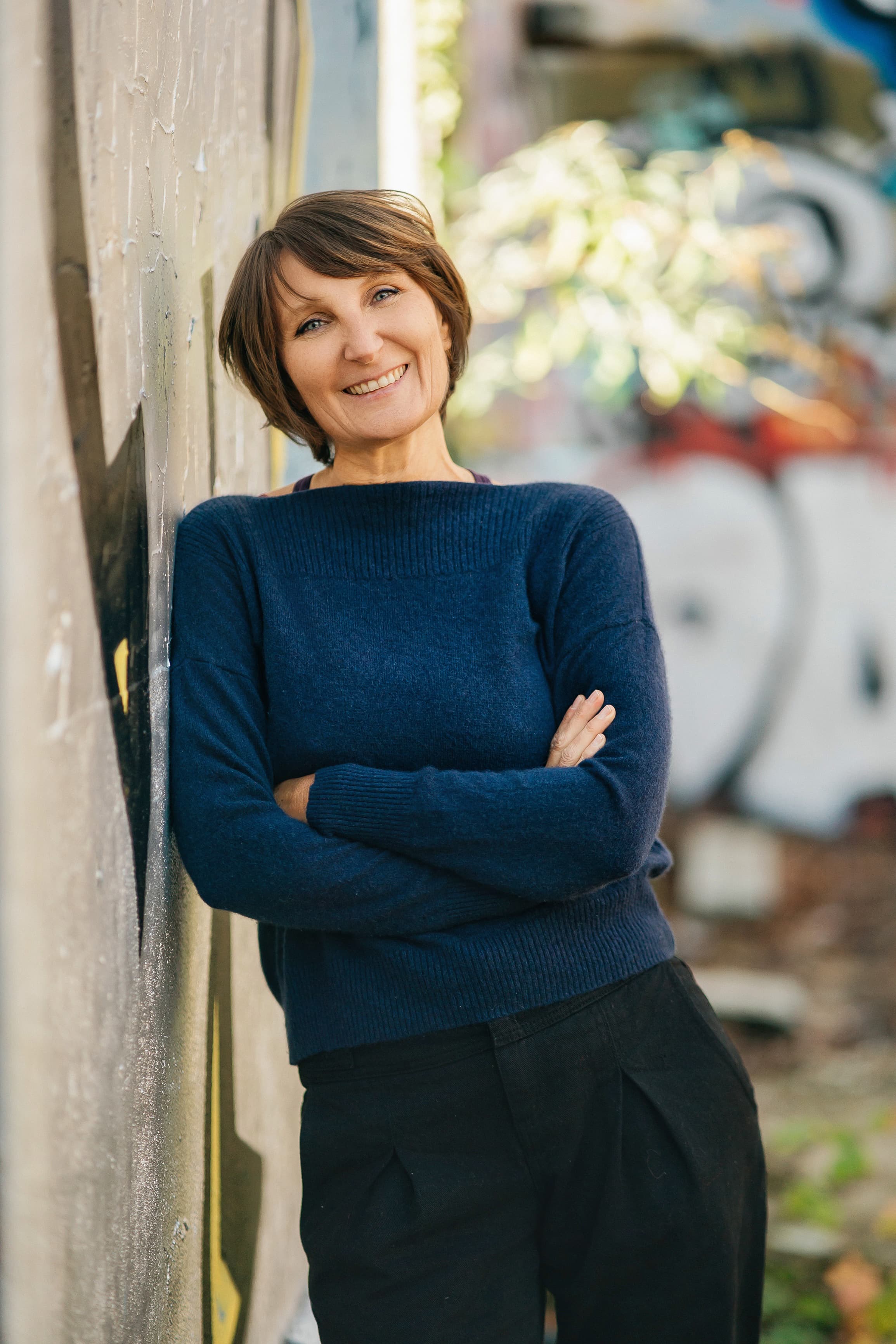 portrait en pieds de Nathalie Ranno &eacute;paule contre un mur graff&eacute;